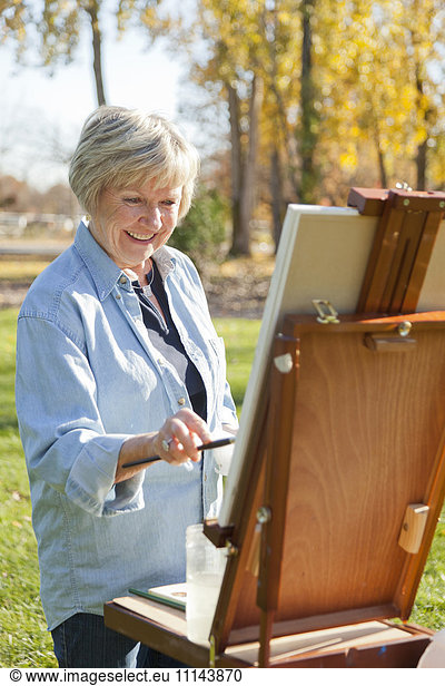 Senior woman painting outdoors