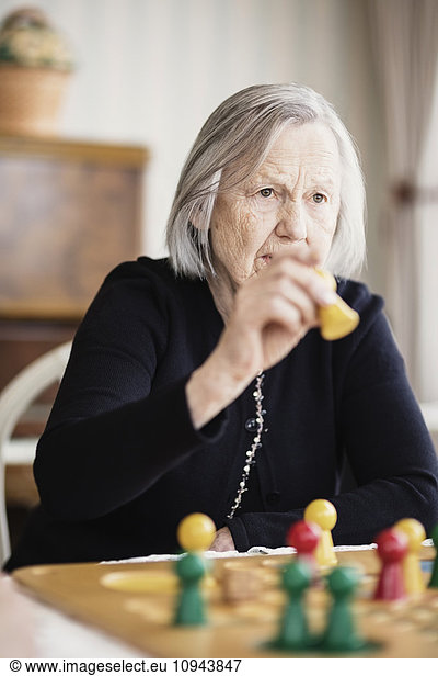 Senior woman playing Ludo at nursing home