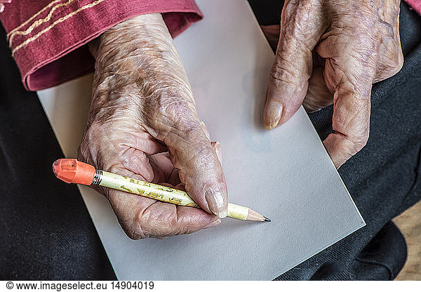 Senior woman's hands getting ready to write a note with a pencil; Olympia  Washington  United States of America