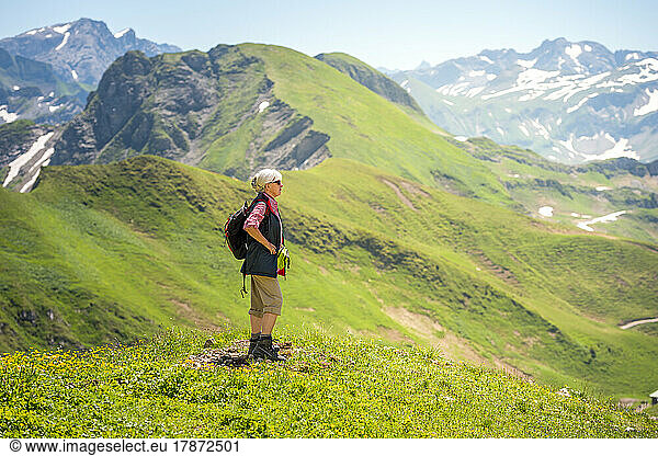 Senior woman standing on mountain looking into valley  Mountain Nebelhorn  Allgau  Bavaria  Germany