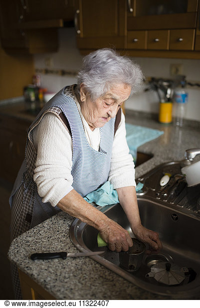 Senior woman washing dishes in kitchen
