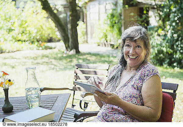 Senior woman with a digital tablet in the garden  Altötting  Bavaria  Germany