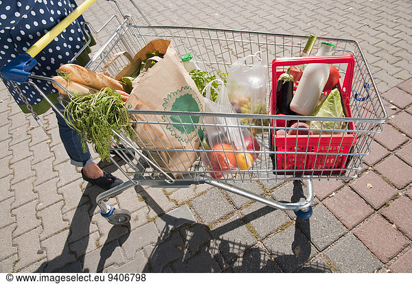 Senior woman with shopping cart filled