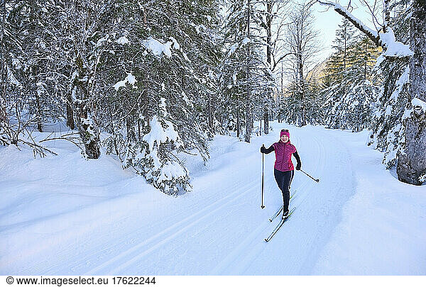 Senior woman with ski pole skiing in snow on vacation