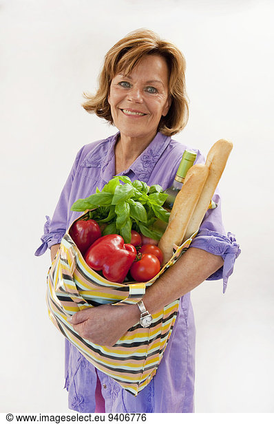 Senior woman with vegetable shopping bag  smiling  portrait