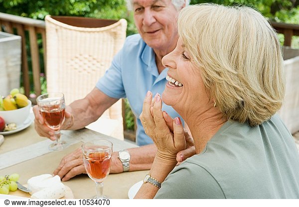 Seniorenpaar beim Essen und Trinken von Wein
