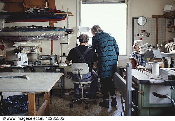 Seniorinnen und Seniorinnen diskutieren während der Arbeit in der Werkstatt