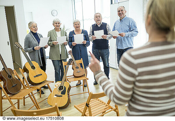 Seniors in retirement home making music singing in choir