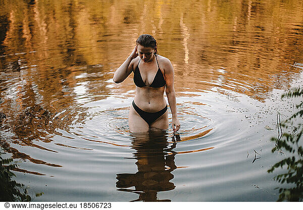 Sensual woman in a bikini standing in water