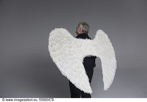 Serene man wearing angel wings  looking up