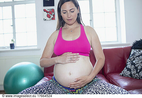 Serene pregnant woman exercising at home