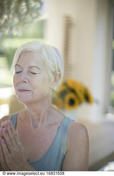 Serene senior woman meditating with eyes closed