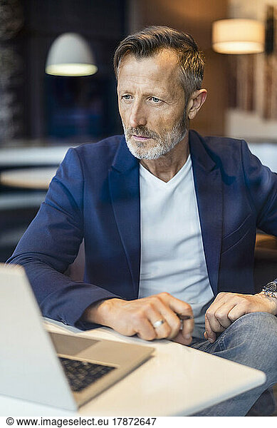 Serious businessman looking at laptop