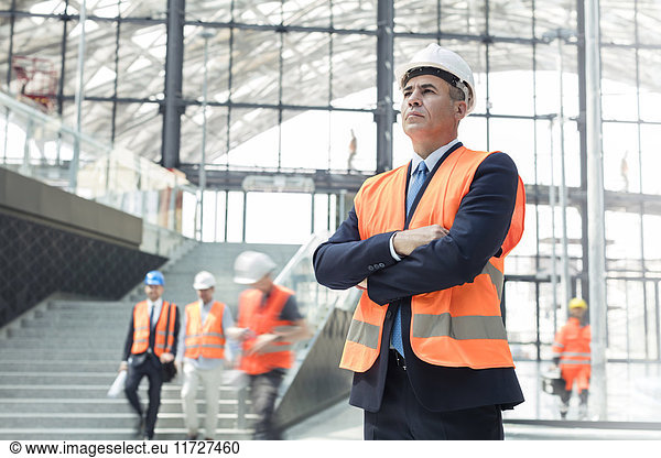 Serious businessman wearing hard-hat at construction site