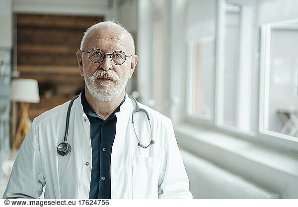 Serious doctor wearing eyeglasses at medical clinic