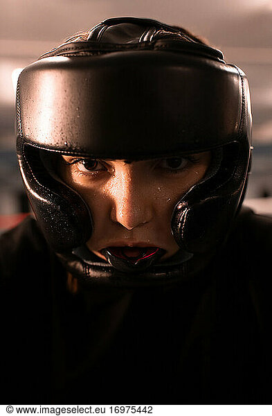 Serious female fighter in protective gear before fight