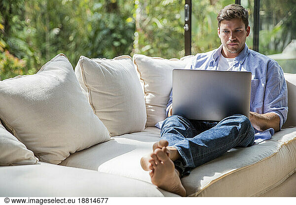 Serious freelancer working on laptop at home