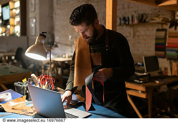 Serious man with leather browsing laptop