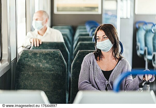 Serious passengers in protective masks during their train day trip