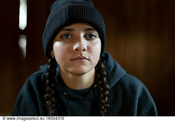 Serious teen girl with beanie wearing braids