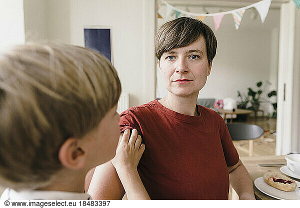 Serious woman with son at home