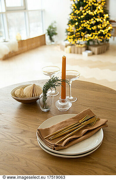 Served table in brown colors with a view of the Christmas tree