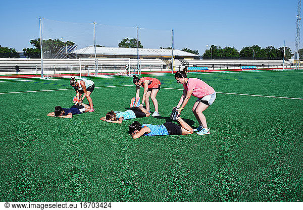 several young women practice stretching after training