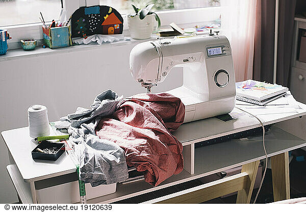 Sewing machine with clothes on table