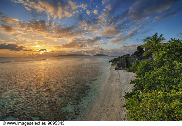 Seychellen  La Digue  Blick auf die Anse Source d' Argent mit skulptierten Felsen und Palmen bei Sonnenuntergang