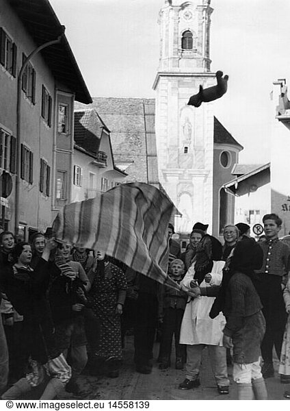 SG hist.  Feste  Partenkirchener Fasching  Mittenwalder 'SchellenrÃ¼hren'  'Jacklschutzen'  TeddybÃ¤r wird auf einem Tuch in die Luft geworfen  Mittenwald  1956