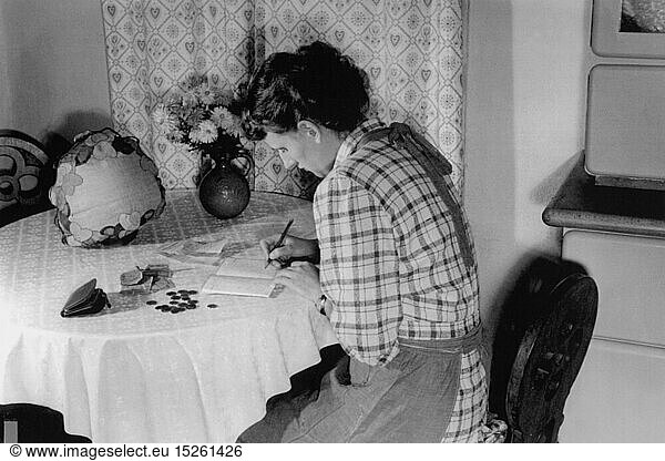 SG hist.  Haushalt  Frau sitzt am KÃ¼chentisch und fÃ¼hrt ein Haushaltsbuch  1940er Jahre