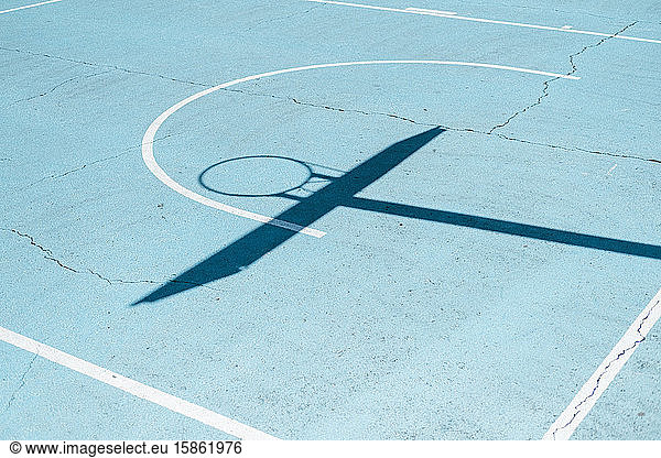 Shadow of a basketball hoop on colorful court