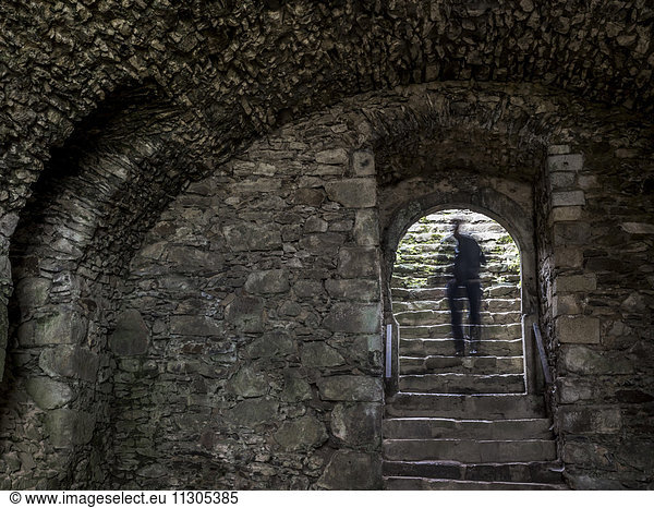Shadow of a man on stairs of a castle vault