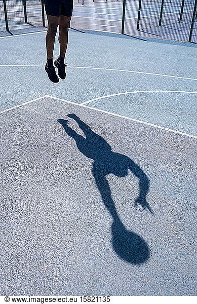 Shadow of a man playing basketball on basketball court  dunking
