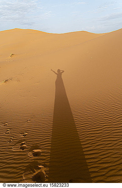 Shadow of a woman on sand dunes in Sahara Desert  Merzouga  Morocco