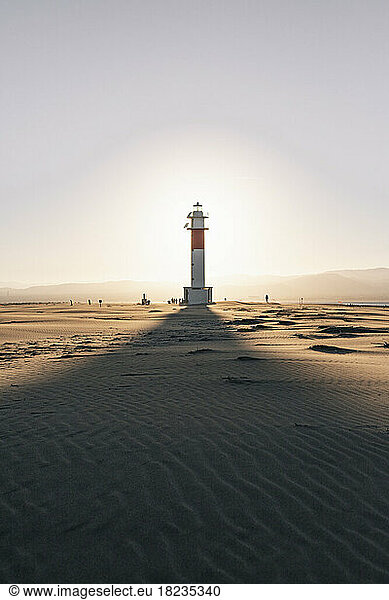 Shadow of lighthouse on sand at beach