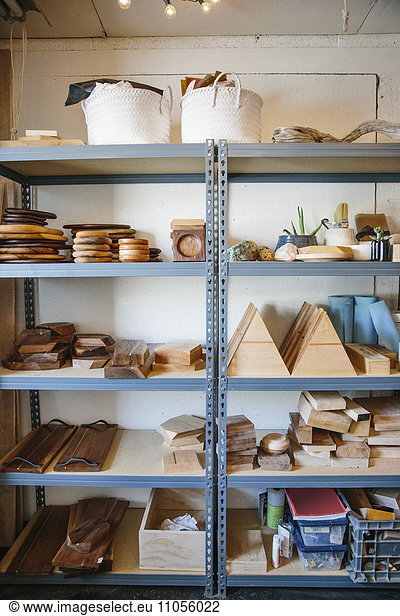 Shelves in a wood turner's workshop and a display of smooth wooden blocks and round platters and bowls.