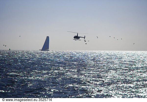 Ship sailing and helicopter flying over sea