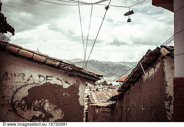 shoes hang on wires above old decayed street in peru