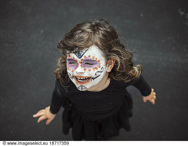 shot from above of girl with face painted smiling