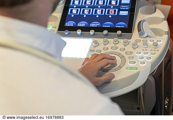 shot of a caregiver's hand  using the keyboard of an ultrasound