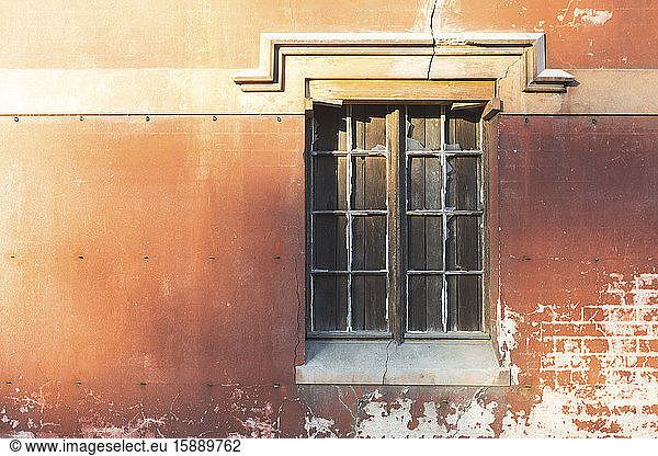 Shuttered window in old brick wall