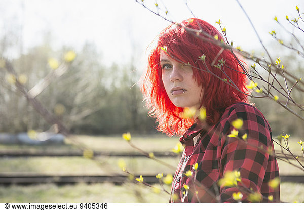 Shy teenage Punk girl fashion dyed bright red hair