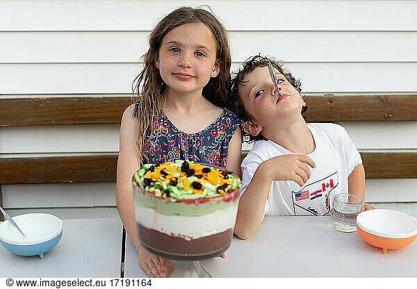 Siblings eating dessert in their backyard