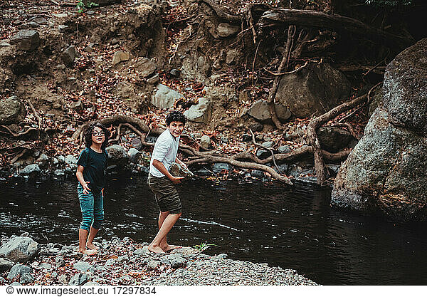 Siblings enjoying themselves on the banks of a river