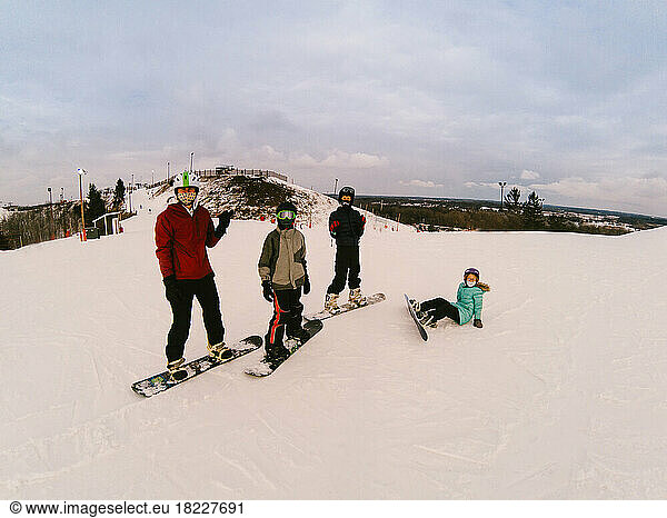 Siblings ready to snowboard down ski hill together in snow winter