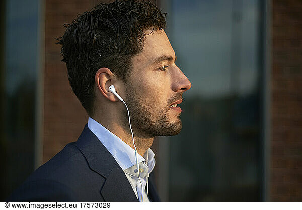 Side profile of a business man in a suit looking at the sun
