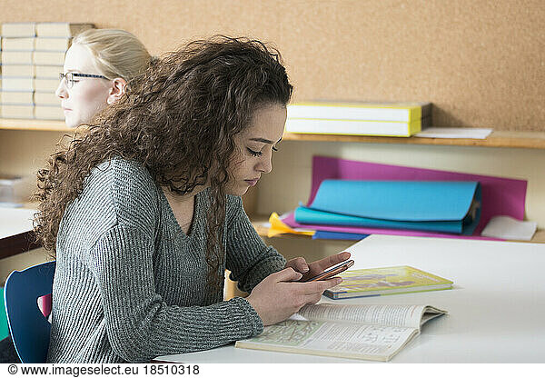 Side profile of a young woman text messaging on mobile phone School  Bavaria  Germany