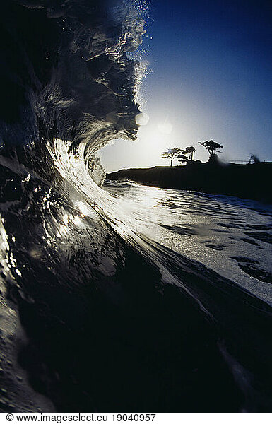 Side view of a high wave in the late afternoon shot from inside the water in Santa Cruz  California.