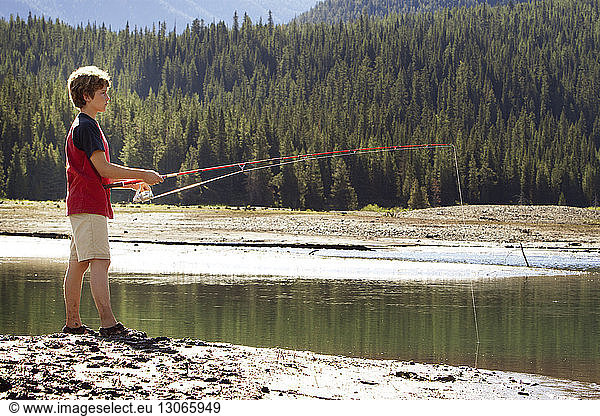 Side view of boy fishing in lake